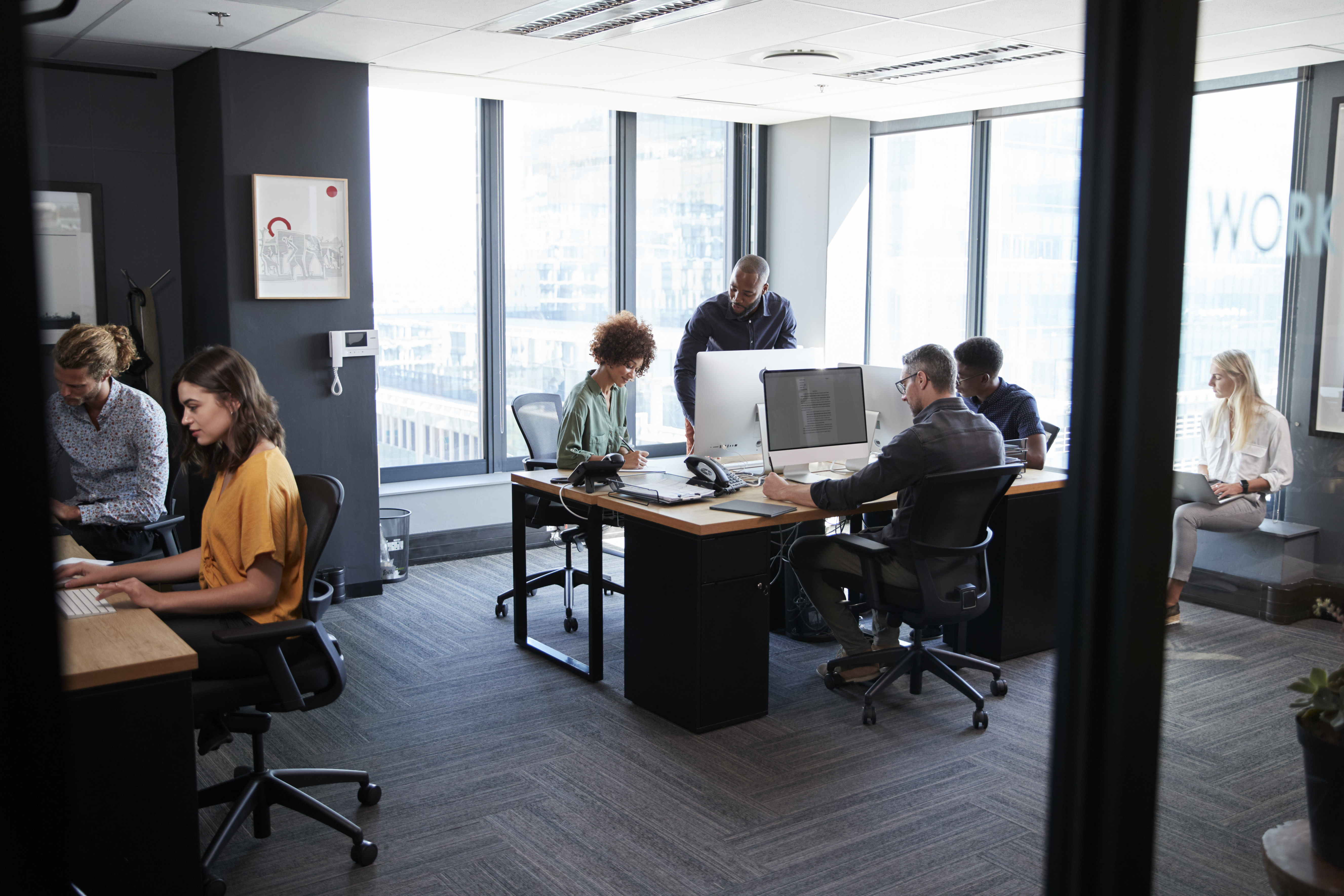 High-performance team working together at computers in a modern office