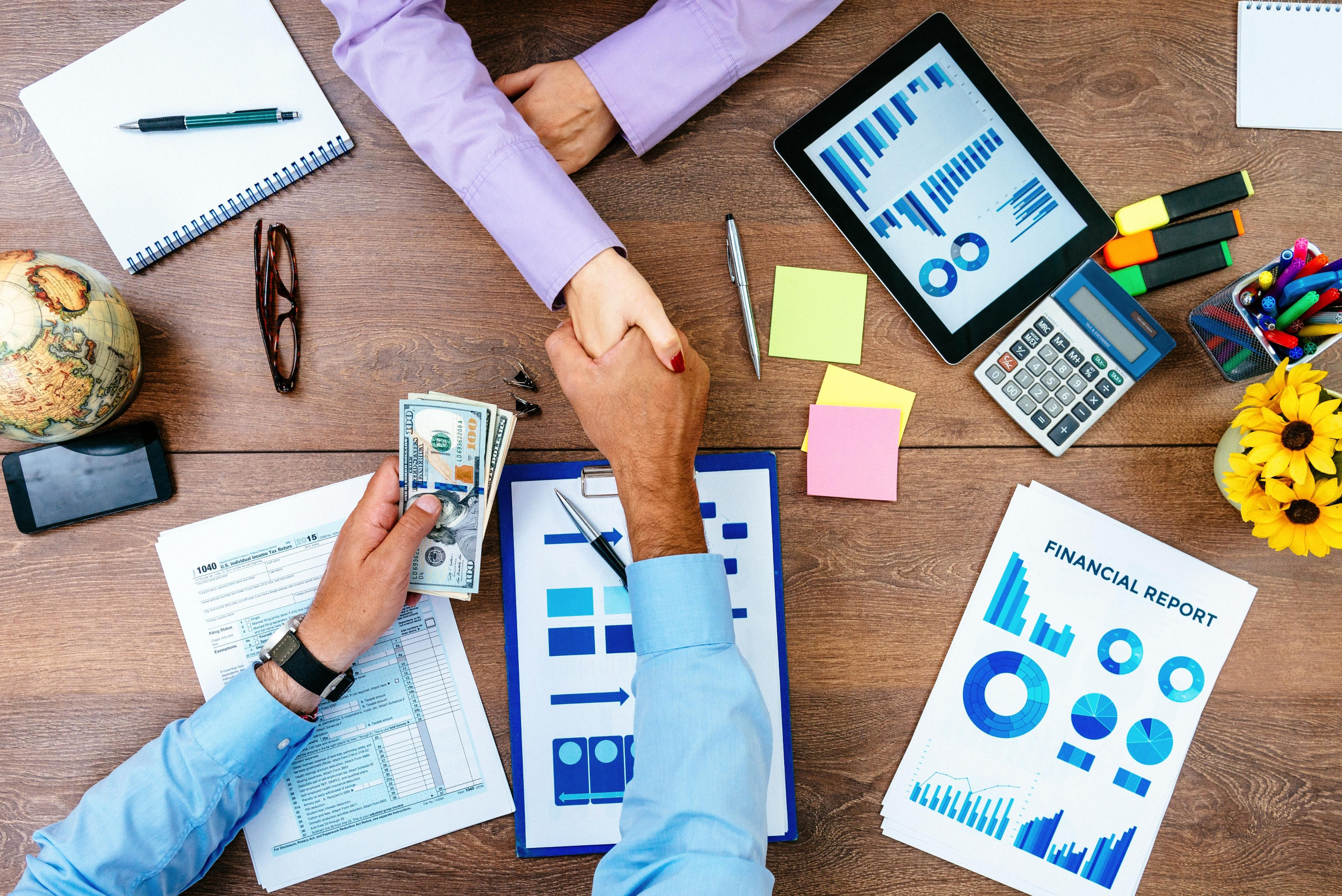 Business handshake over financial report