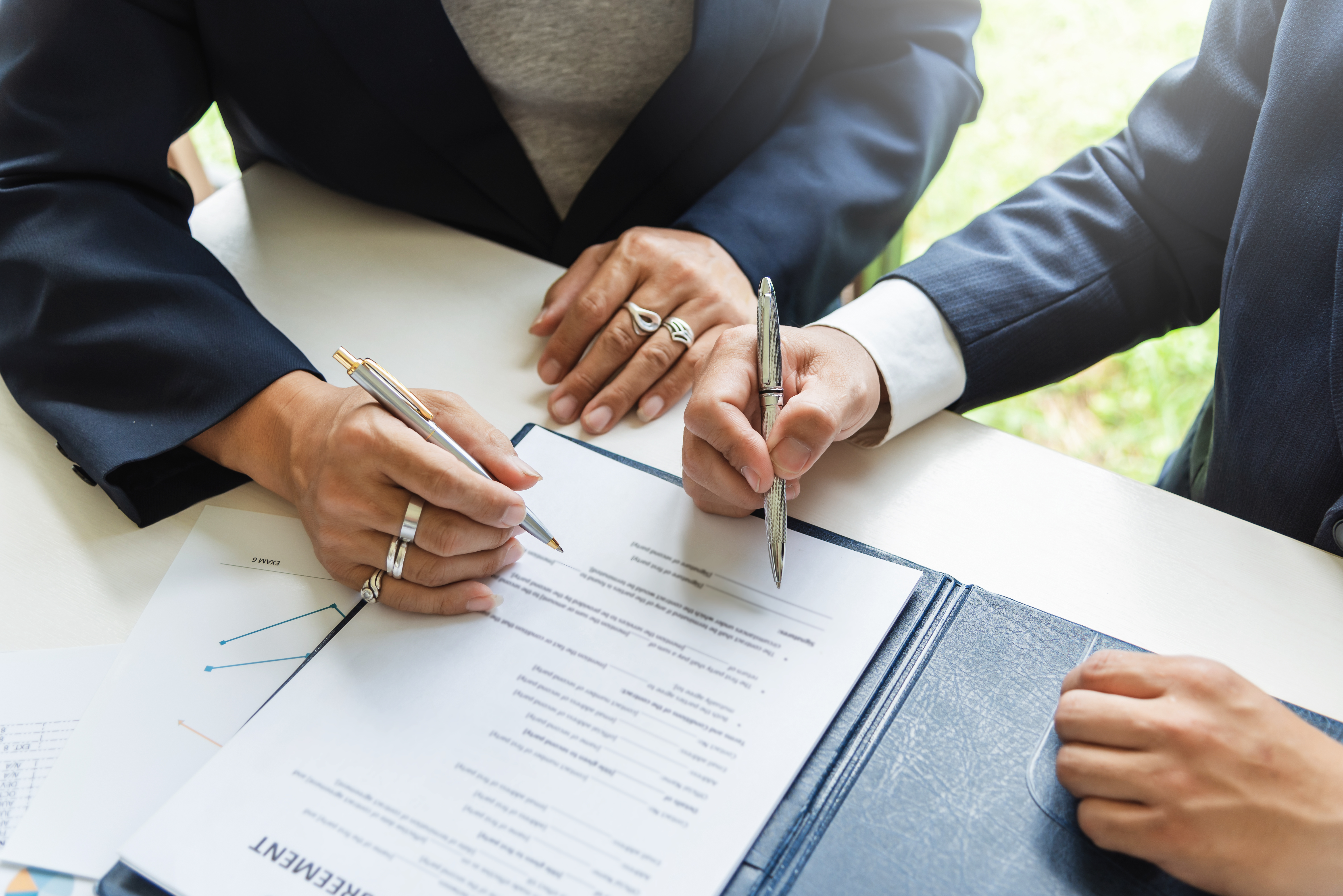 Business professionals signing agreement documents